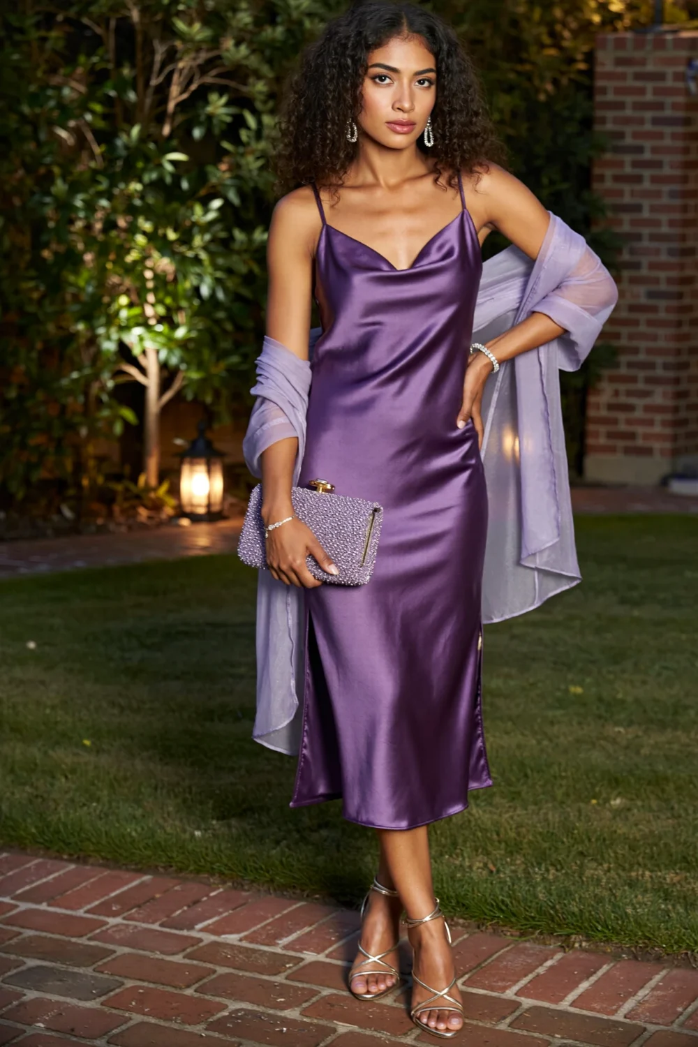 Woman in a deep amethyst silk-satin slip dress, lilac wrap, champagne sandals, and beaded clutch for a luxe garden-party look