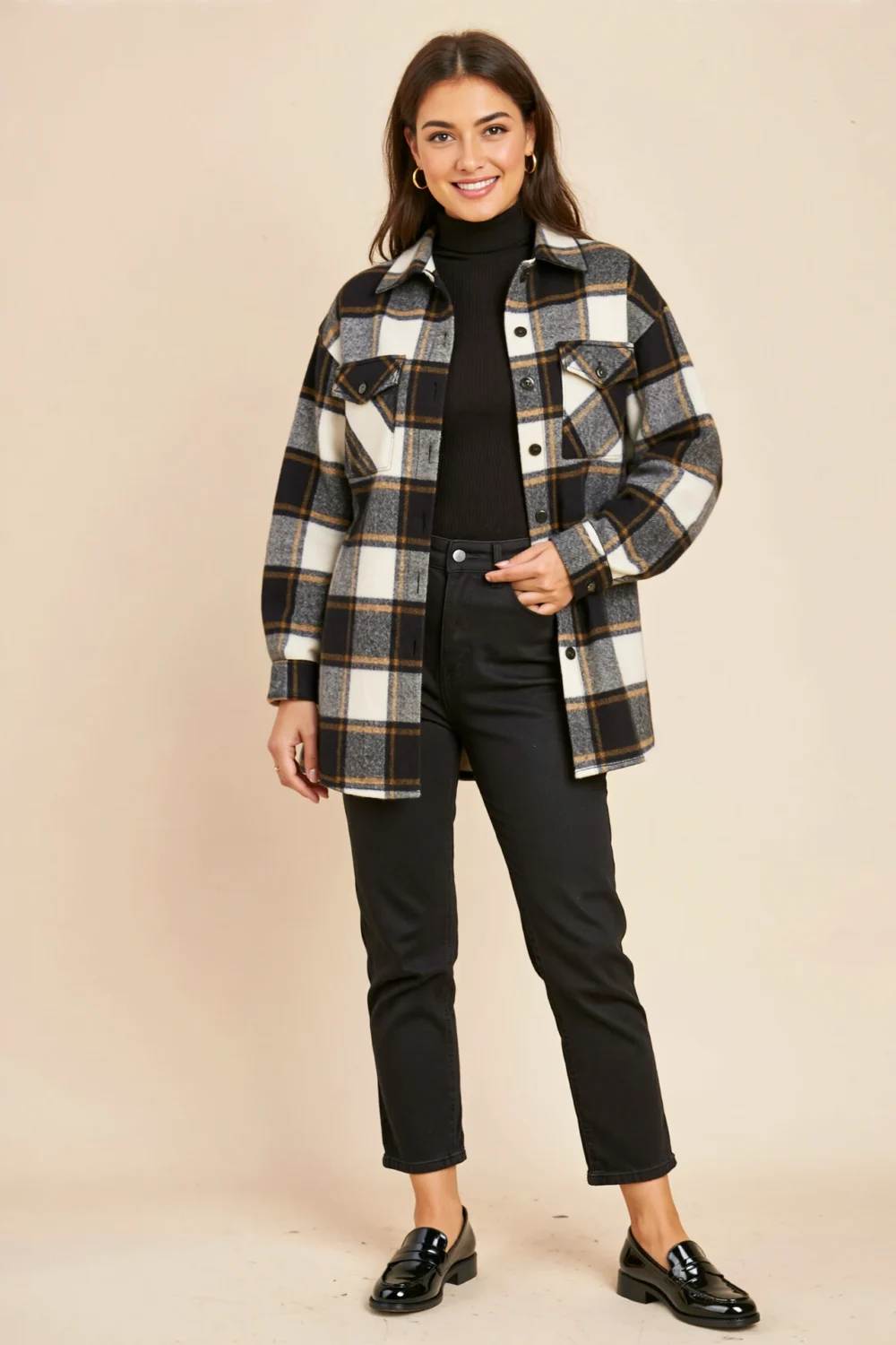 Woman in black jeans, ribbed turtleneck, and plaid shacket with loafers, creating a relaxed, warm Halloween-ready fall outfit