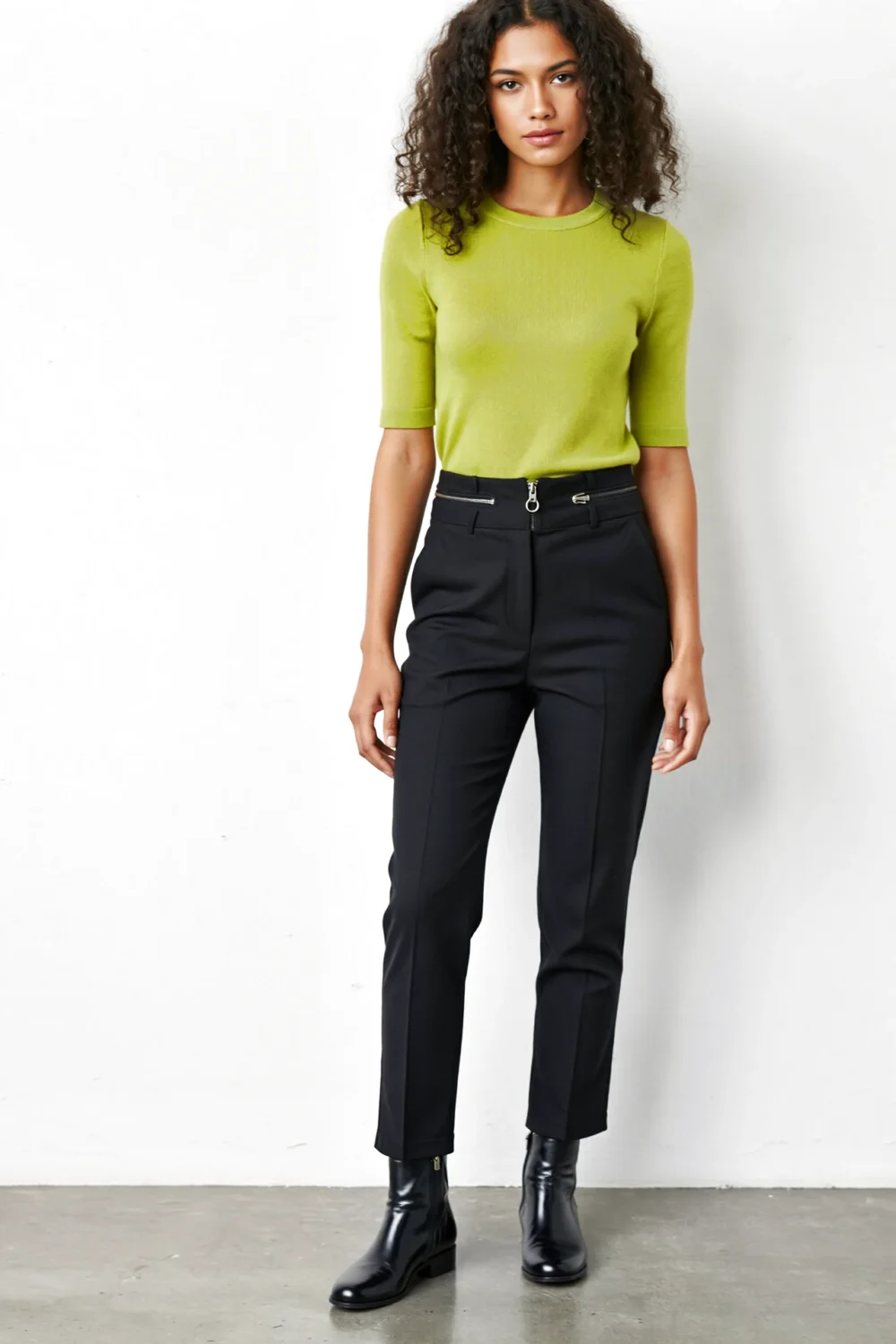 Model wearing bright lime top with tailored black pants and black boots, showing a polished neon-and-black outfit pairing.