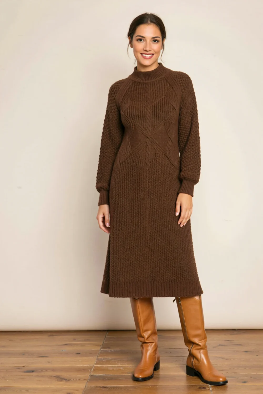 Woman in chocolate ribbed sweater midi dress with mock neck, paired with tan knee boots for a polished autumn look indoors