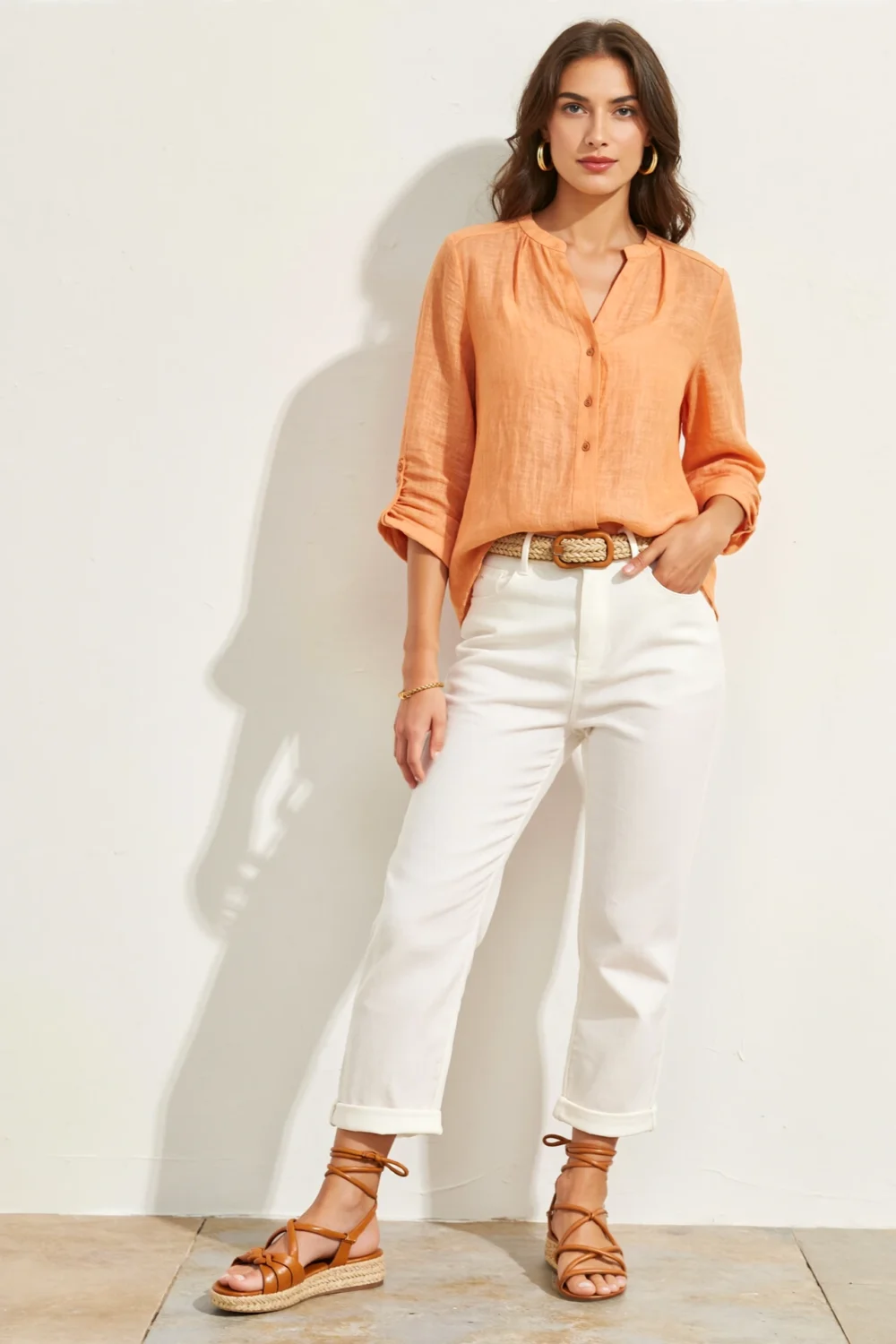Citrus orange blouse tucked into white chinos, finished with braided tan sandals and woven belt for a bright summer look