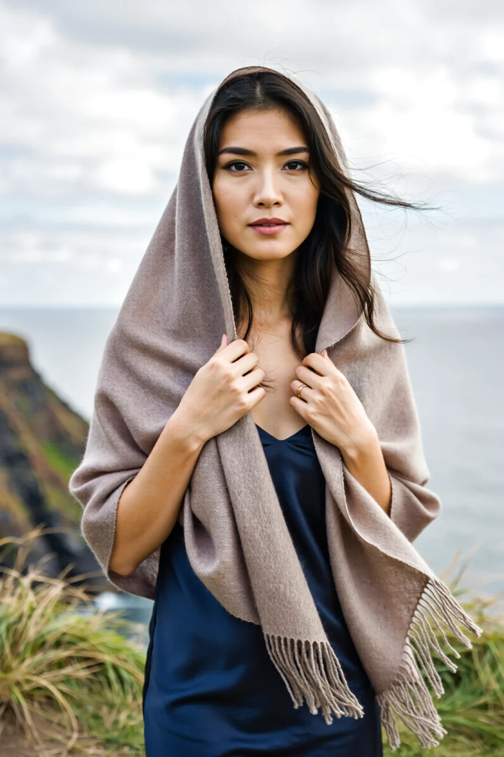 Convertible wide pashmina styled as a hooded shawl on a woman at cliffs, a versatile wedding scarf for ceremony, travel and warmth