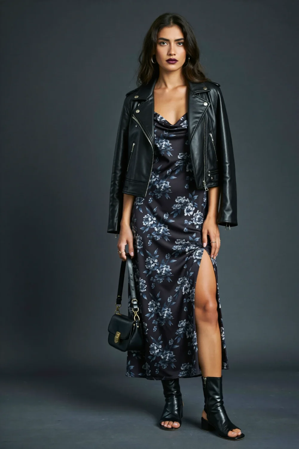 Woman styling a dark floral slip dress with a cropped leather blazer, creating a moody evening look with edgy, feminine flair.
