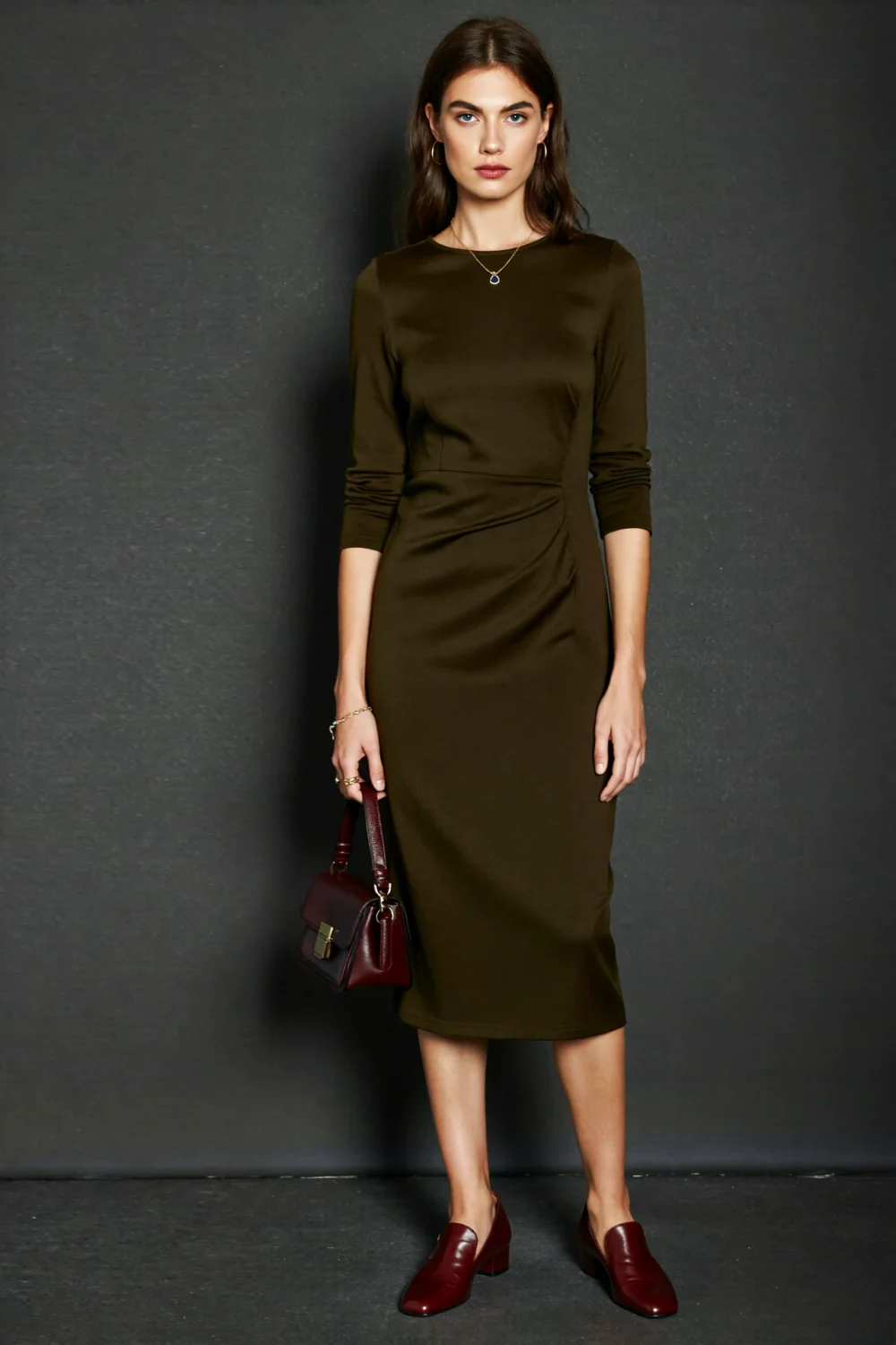 Model in dark olive midi dress paired with burgundy oxblood loafers and matching handbag for a polished moody monochrome look with depth