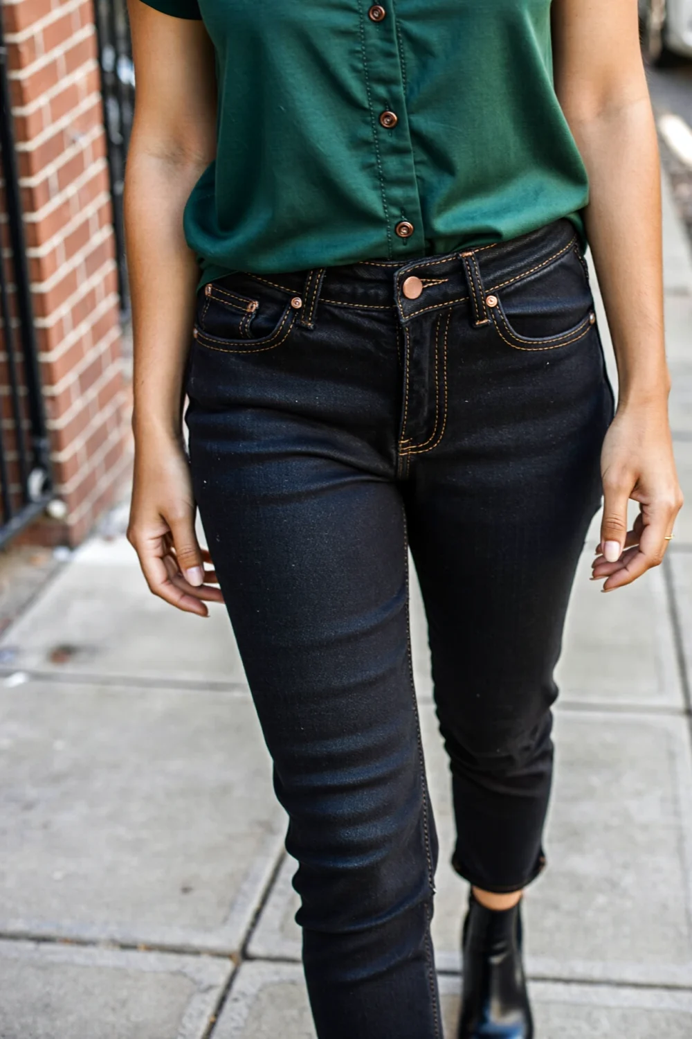 Dark green button-down with black denim jeans and belt, a sleek casual outfit idea for what color pants with green shirt styling.
