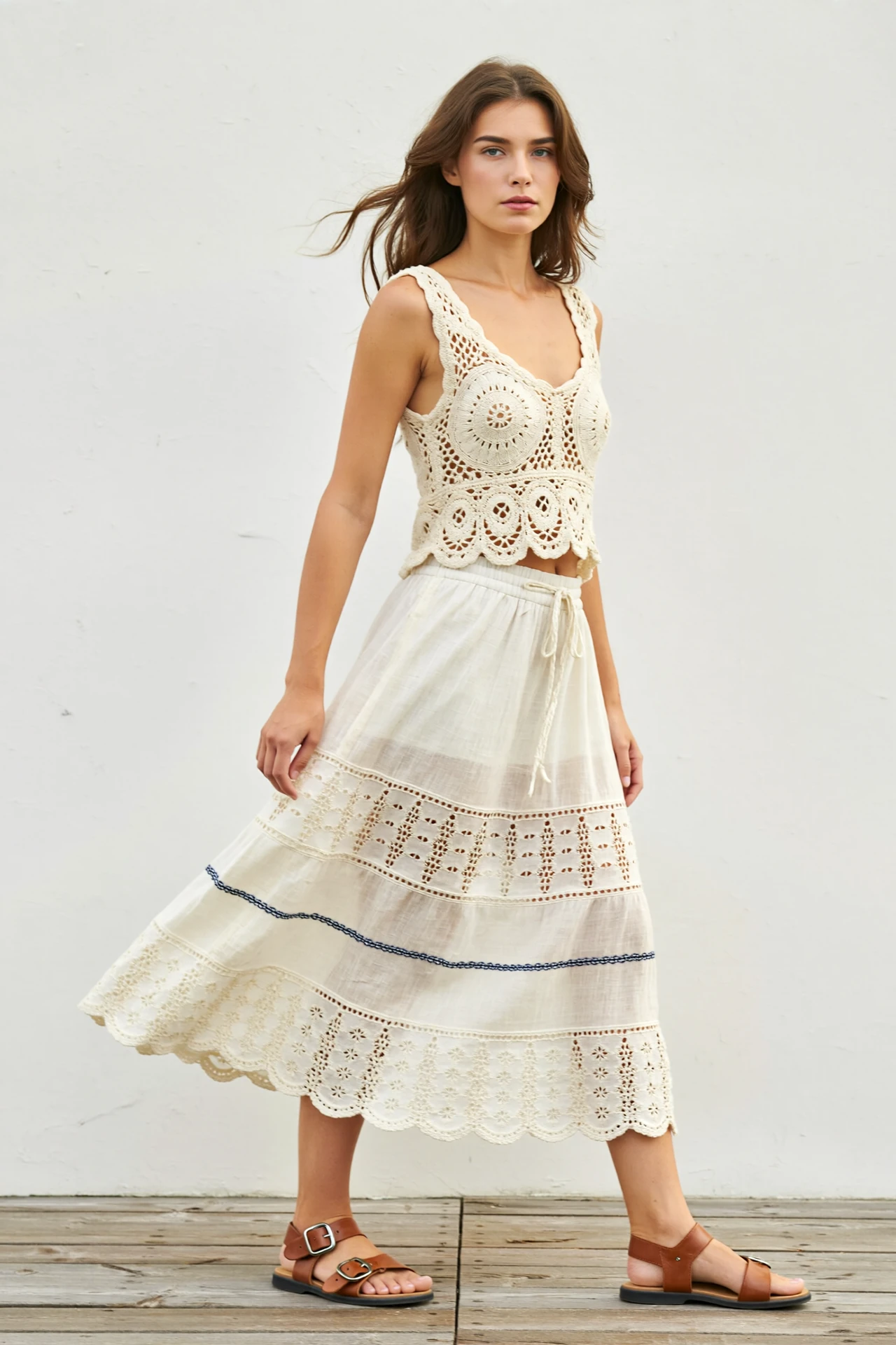 Woman in crochet tank and breezy tiered skirt with leather sandals, a light airy festival outfit for wandering in warm weather