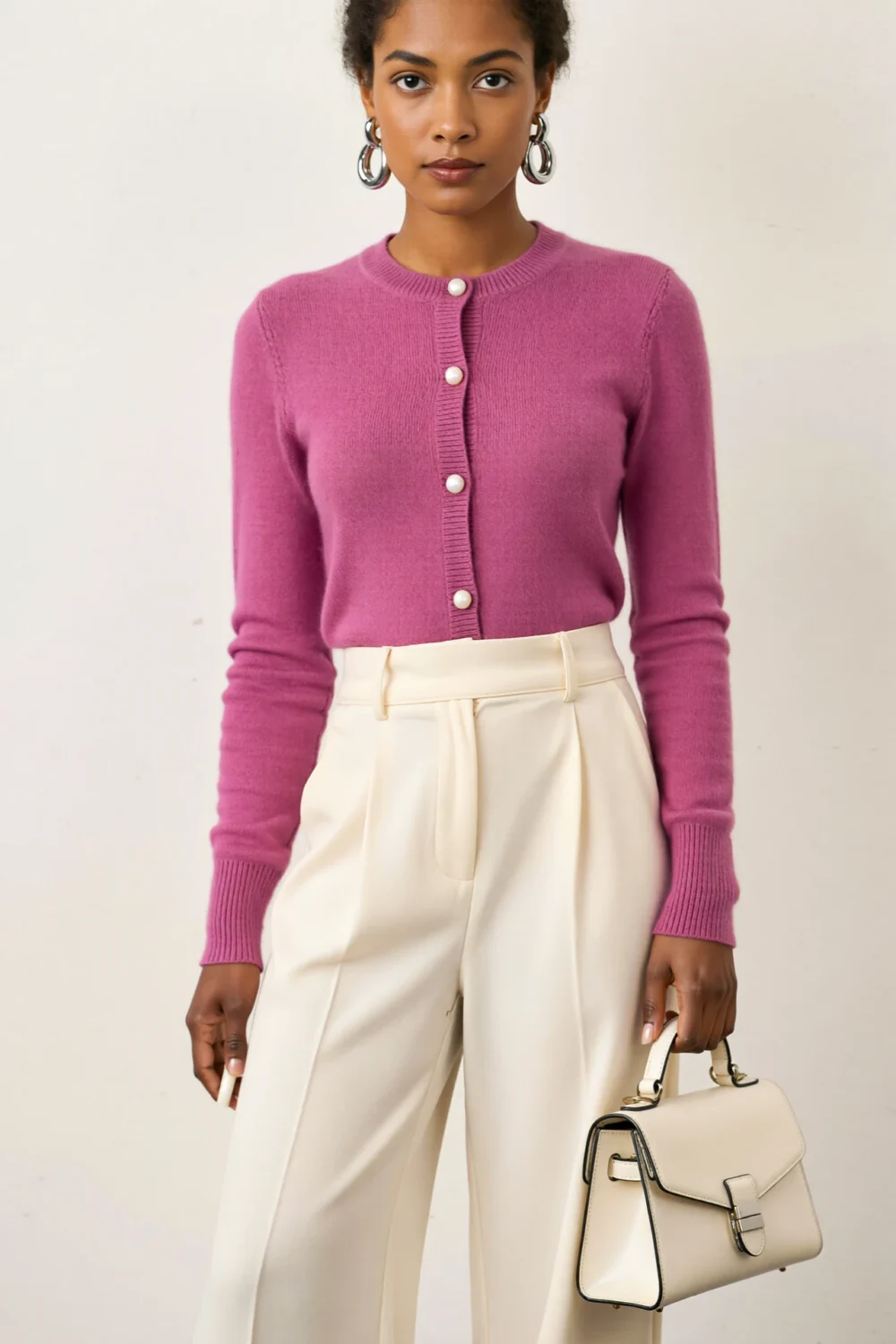 Fuchsia button-front knit with ivory wide-leg trousers, silver hoops, and a structured ivory top-handle bag for polished office style