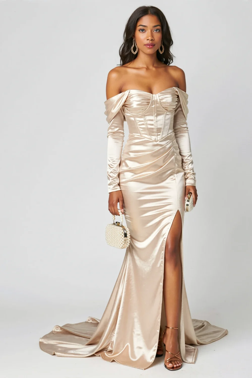 Model in champagne silk-lamé mermaid gown with off-shoulder draping, corset bodice, thigh slit, long sleeves and sweeping train