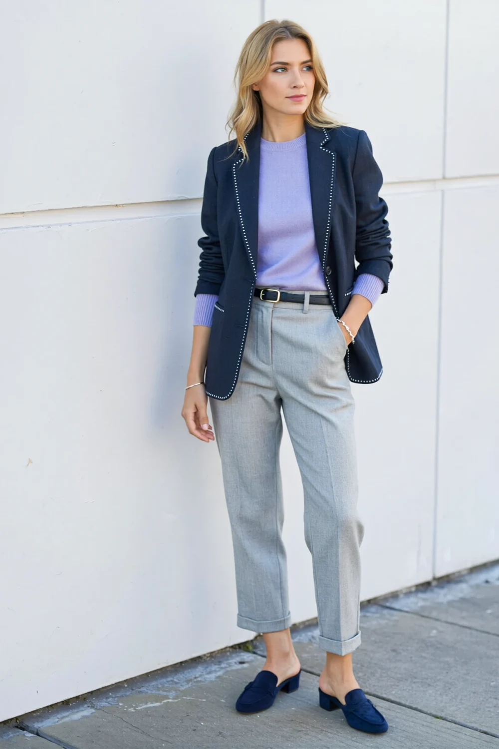 Light grey trousers with lavender knit, navy blazer, and navy loafers create a polished, modern tonal outfit
