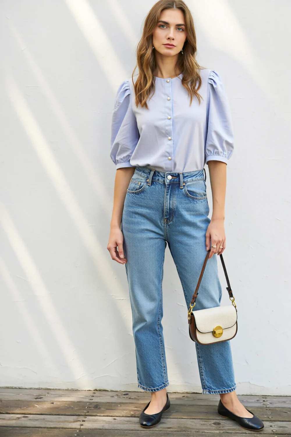 Woman wearing light-wash straight jeans and a pastel puff-sleeve blouse with ballet flats and mini crossbody, spring brunch outfit