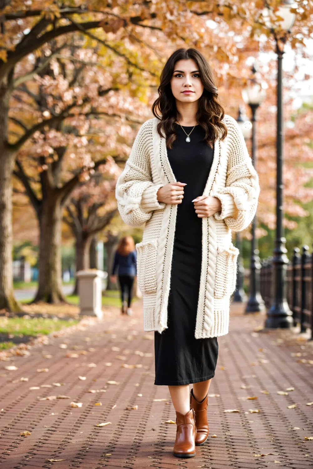 Model on autumn walkway in a cream chunky long cardigan coatigan over a black jersey maxi, cozy boho look elongates silhouette.