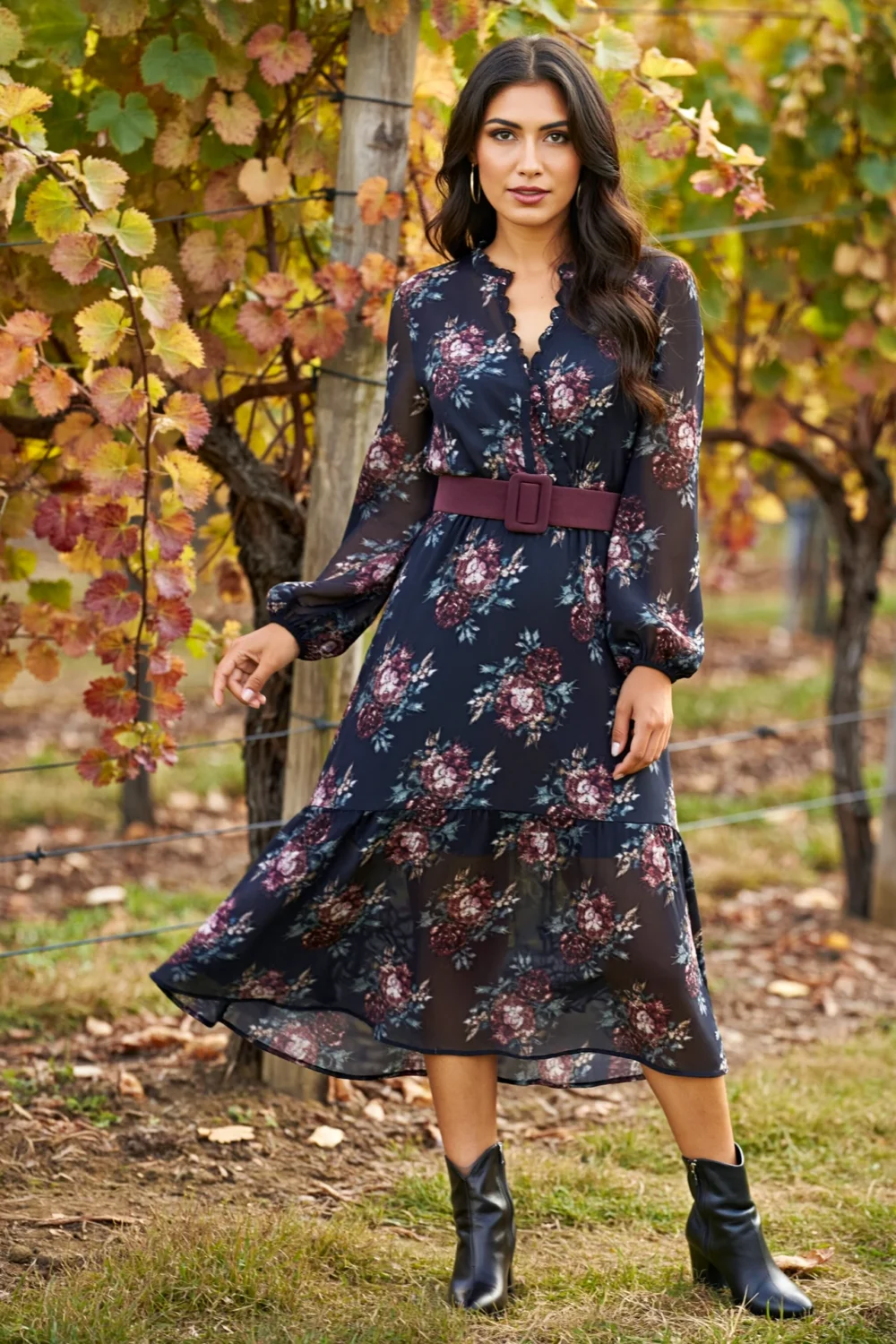 Moody long-sleeve floral midi dress with suede belt and black kitten-heel boots, styled for an autumn vineyard setting