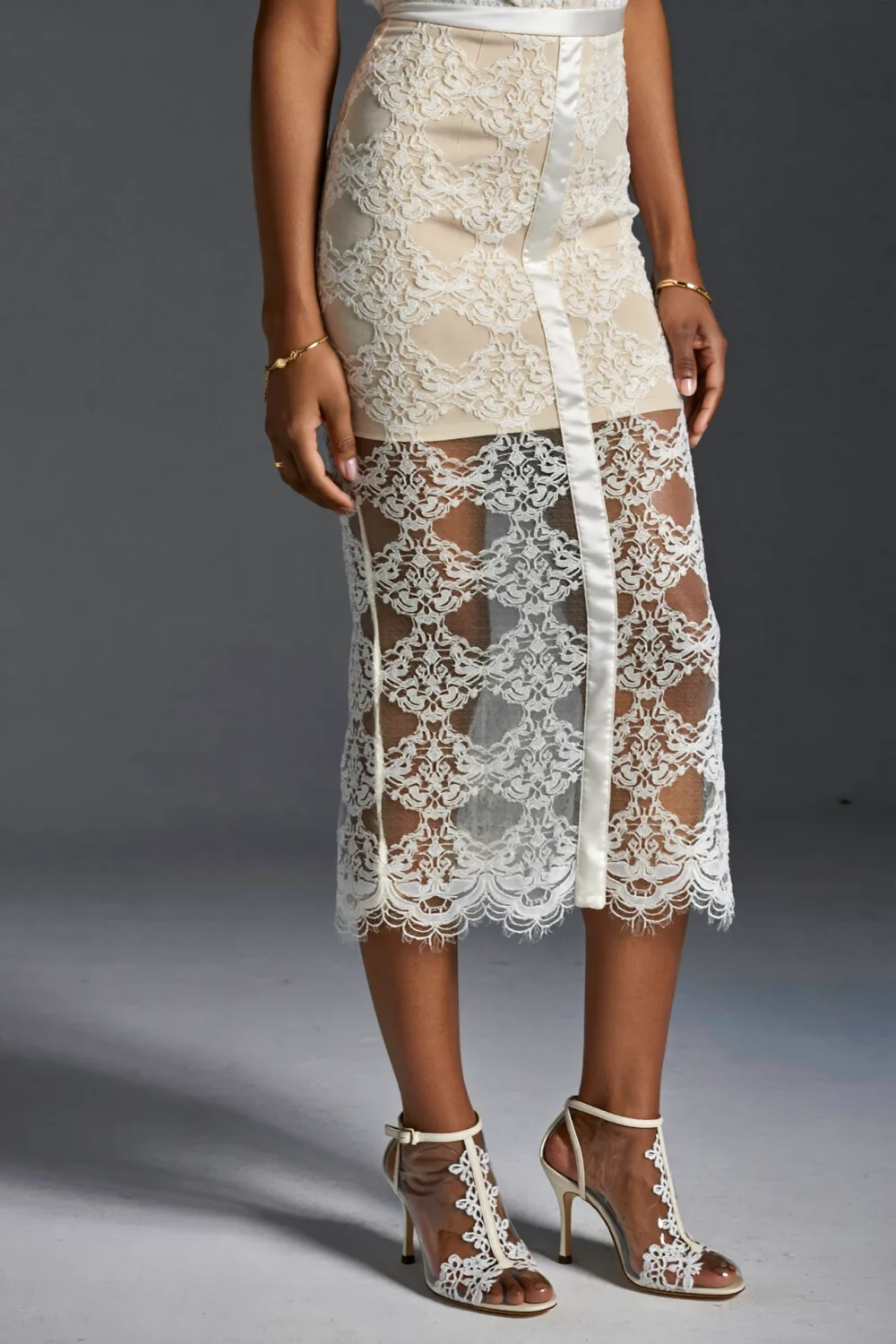 Mesh-and-lace-trim pumps with clear panels complement a white lace dress, adding delicate couture texture and modern transparency