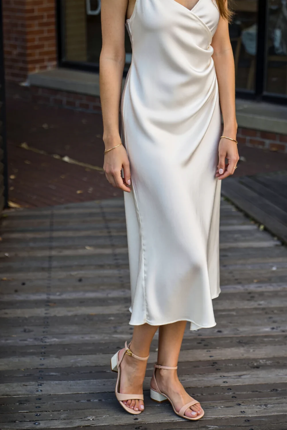 White midi slip dress styled with minimal nude sandals, creating a long, luxe line with barely-there straps and a soft, elegant silhouette