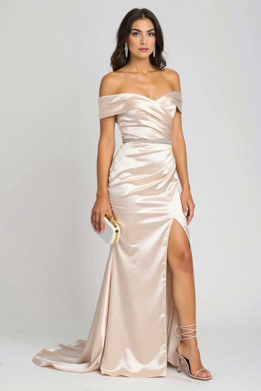 Woman in a molten champagne off-shoulder satin column gown with ruching, high slit, and draped train for an elegant evening look