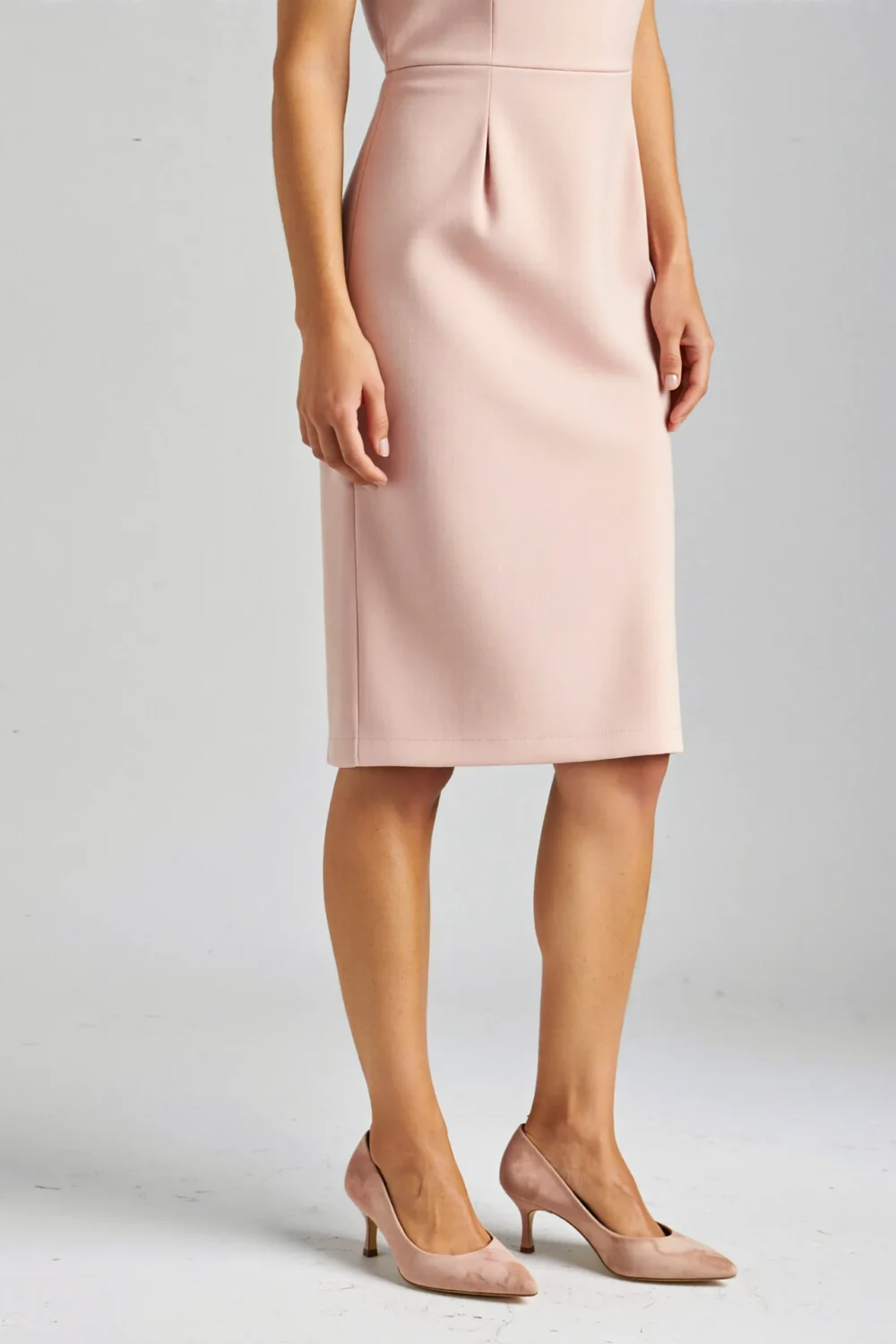 Nude pink pumps with a sleek pointed toe paired with a blush dress, creating a refined, leg-lengthening look for pink outfits