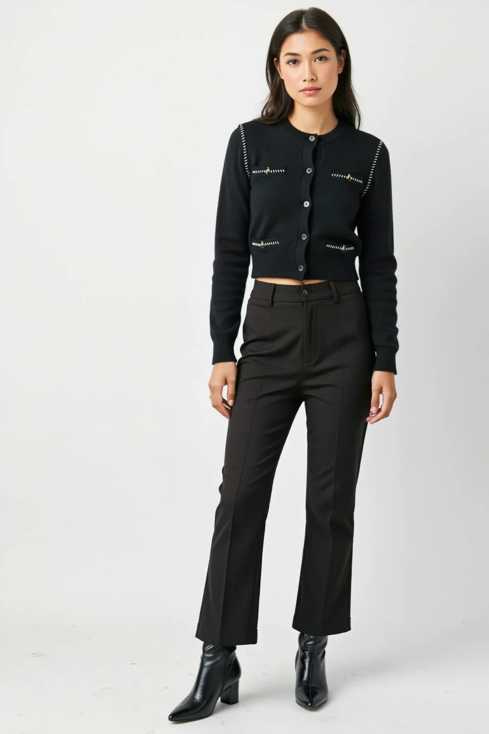 Petite model in cropped black cardigan with high-rise trousers and ankle boots, creating a polished, leg-lengthening silhouette
