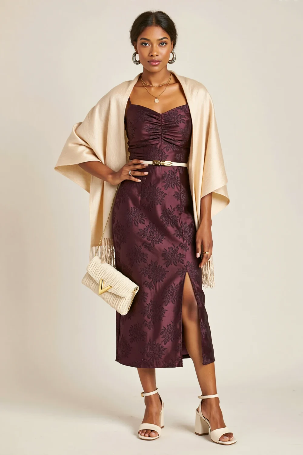 Woman in plum brocade column midi with bateau neckline, champagne wrap, and heels, styled for an elegant fall wedding look