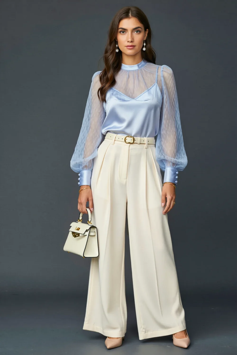 Powder-blue organza blouse with bishop sleeves, ivory wide-leg trousers, and a structured handbag for an airy polished look