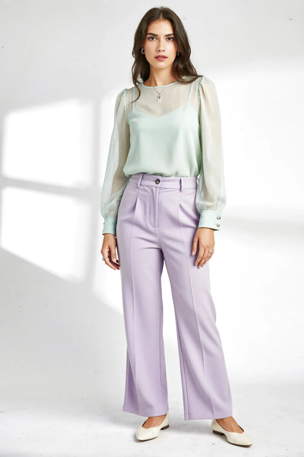 Model in sage chiffon blouse and lavender wide-leg trousers with cream flats, creating a romantic, airy, polished color palette.