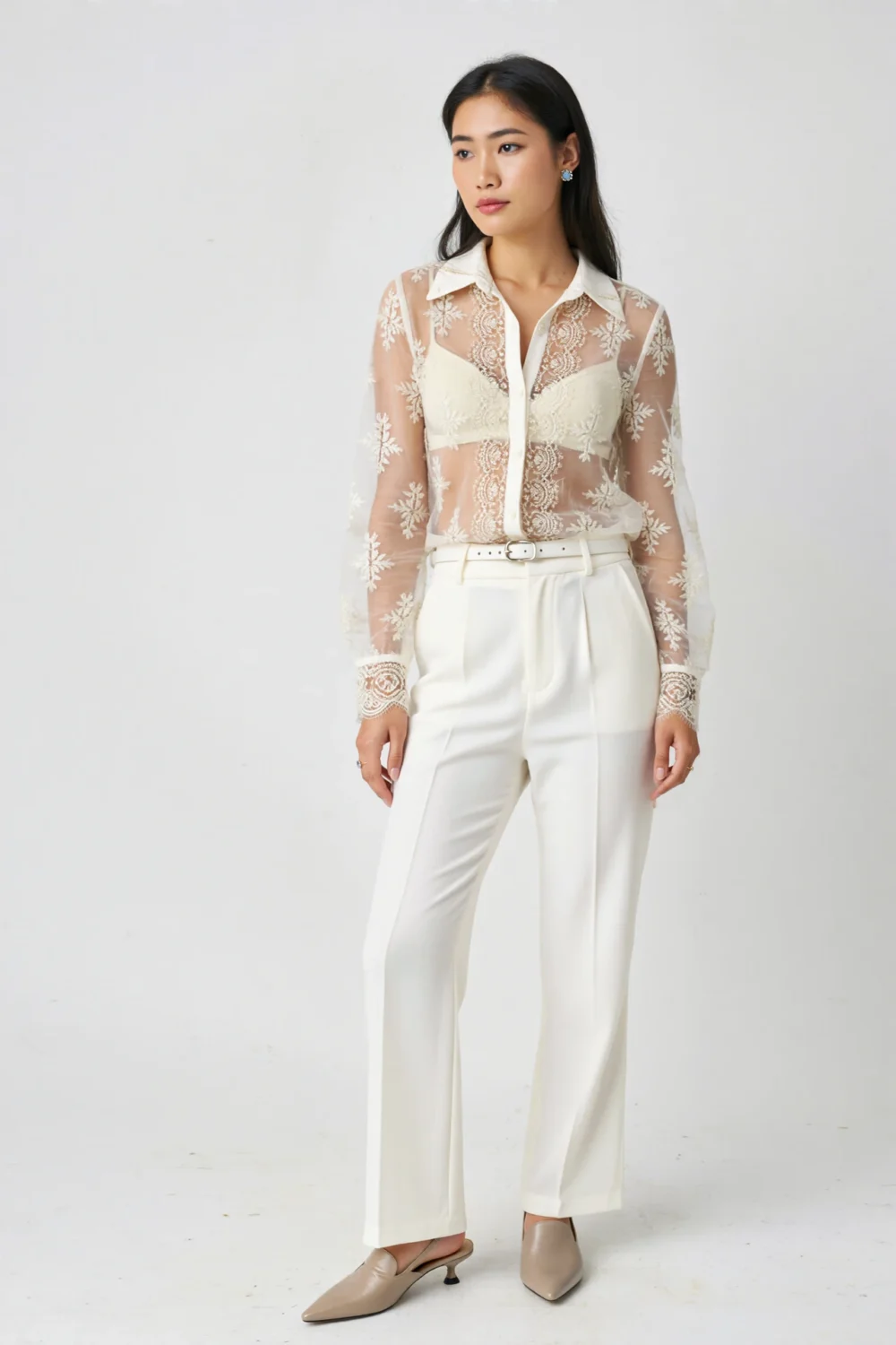 Sheer lace button-up over tonal cami with white trousers and pointed mules, creating a romantic textured monochrome outfit