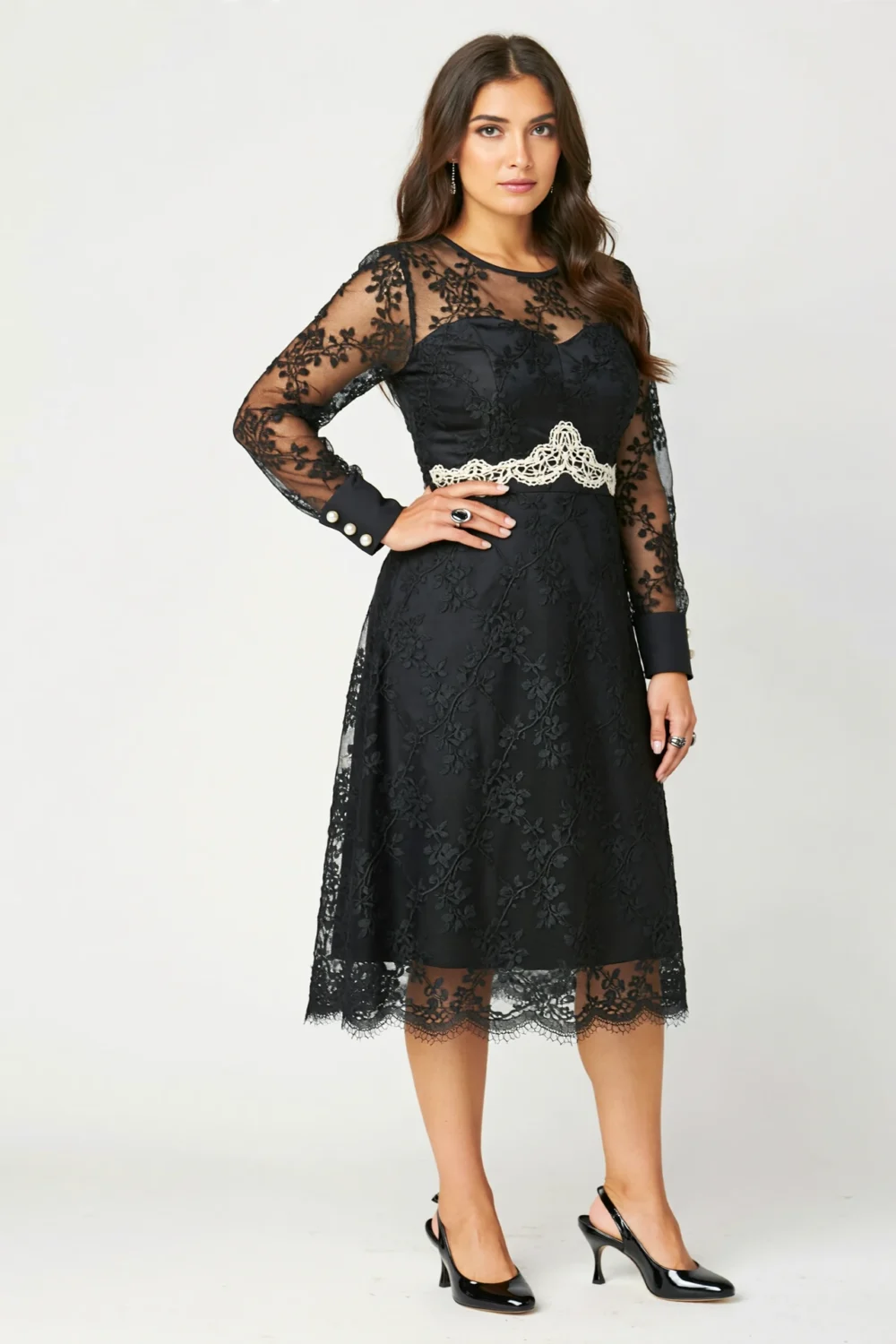 Black lace dress with sheer sleeves, boat neckline and opaque lining, styled with a cinched waist for refined wedding-ready elegance