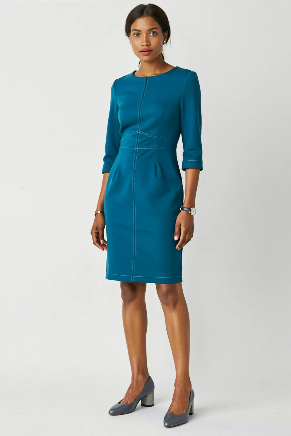 Teal sheath dress styled with slate gray mid-heel pumps, creating a polished, modern office-ready look with a calm, professional feel