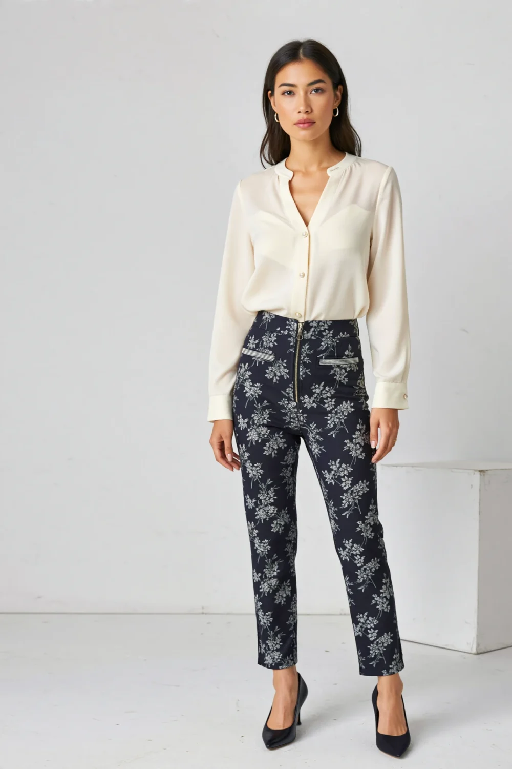 Model wears slim cigarette-cut navy floral print pants with a sleek high waist, cropped ankle length, and refined office-to-dinner style