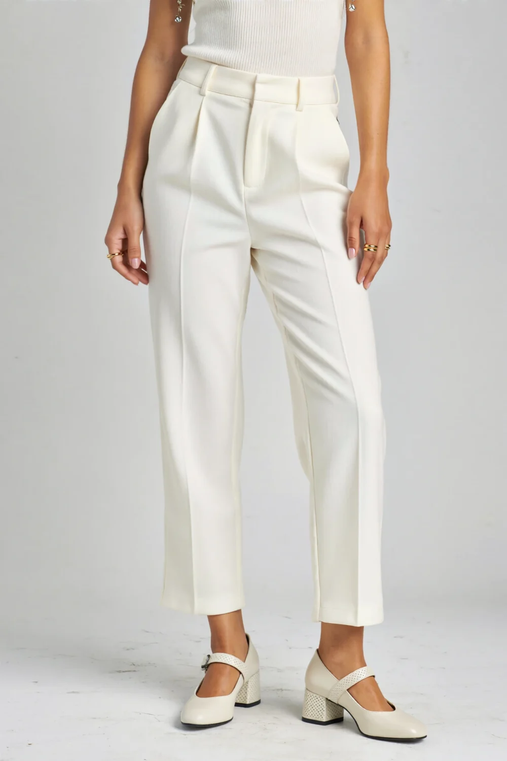Tailored white trousers with cropped hems paired with structured Mary Jane block heels for a polished vintage-modern look