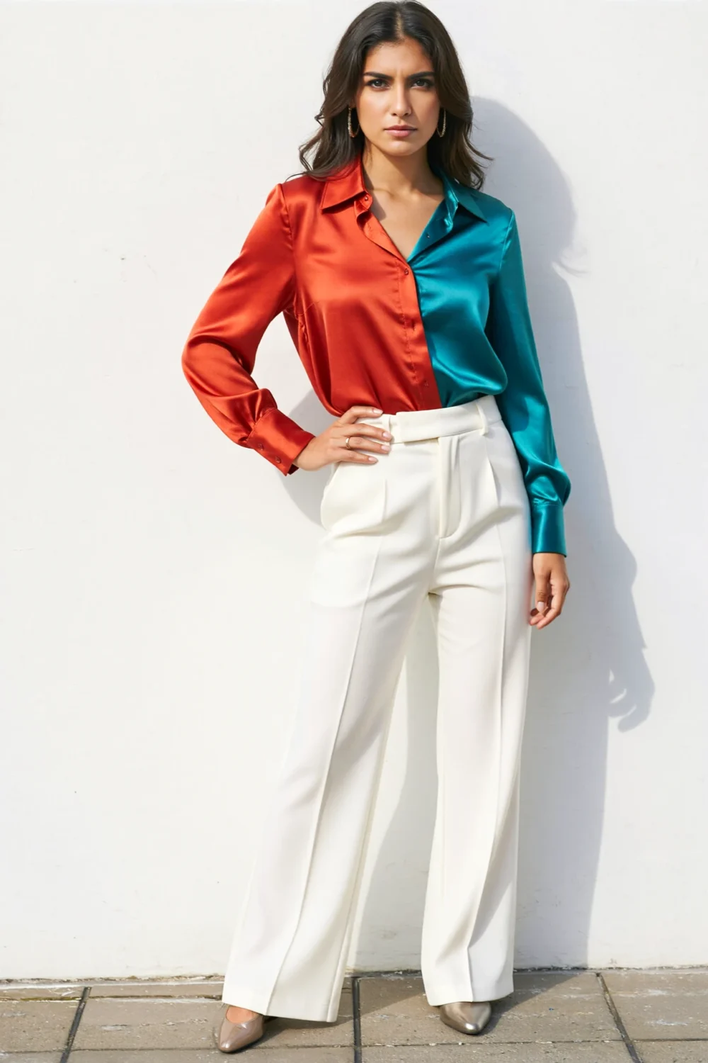 White trousers with a cobalt and cherry red satin blouse, paired with metallic shoes for a sharp, polished bright-color look