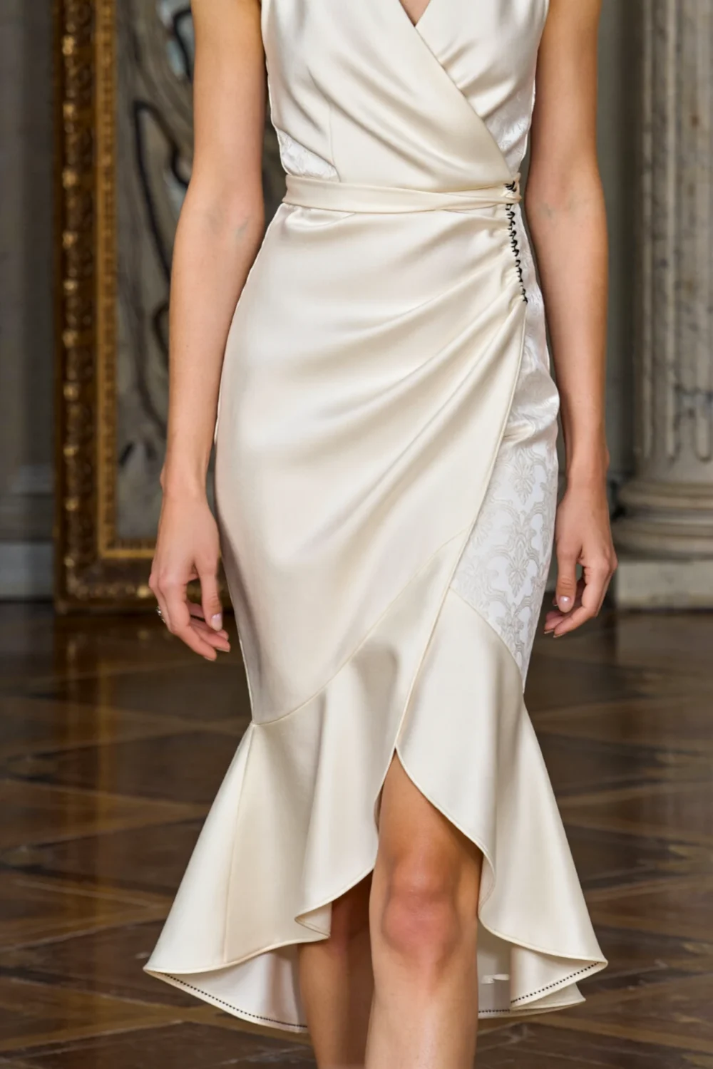 Elegant ivory wrap midi dress with asymmetrical hem, soft drape, and polished silhouette for a formal wedding guest look